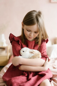 Une jeune fille portant un lapin blanc.